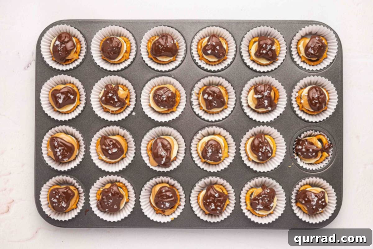 Chocolate pretzel banana bites in a muffin tin, topped with flaky sea salt.
