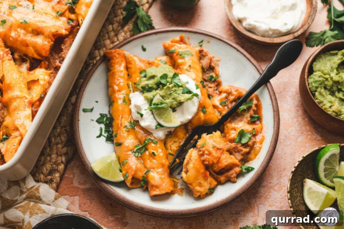 Effortless Enchilada Bake 11 A plate of lazy enchiladas topped with sour cream, guacamole, and fresh cilantro, served with a side of lime wedges.