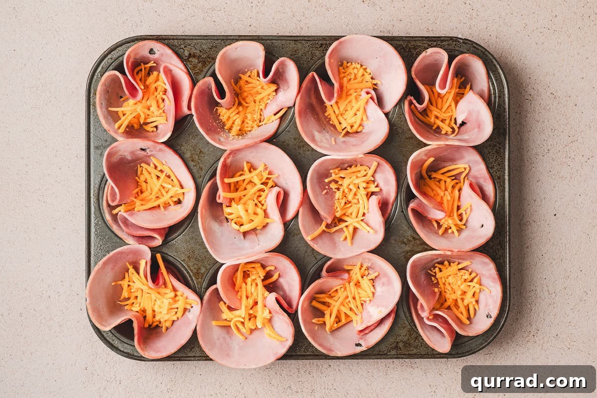 Savory Ham & Cheese Egg Cups for Quick Breakfast or Brunch 5 Ham placed in a muffin pan, with shredded cheese placed on top.