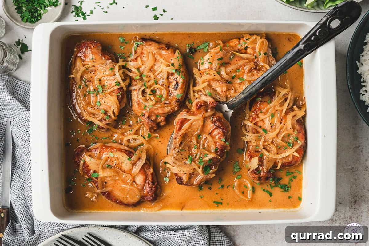 A spatula lifting a pineapple-onion pork chop out of a baking dish.