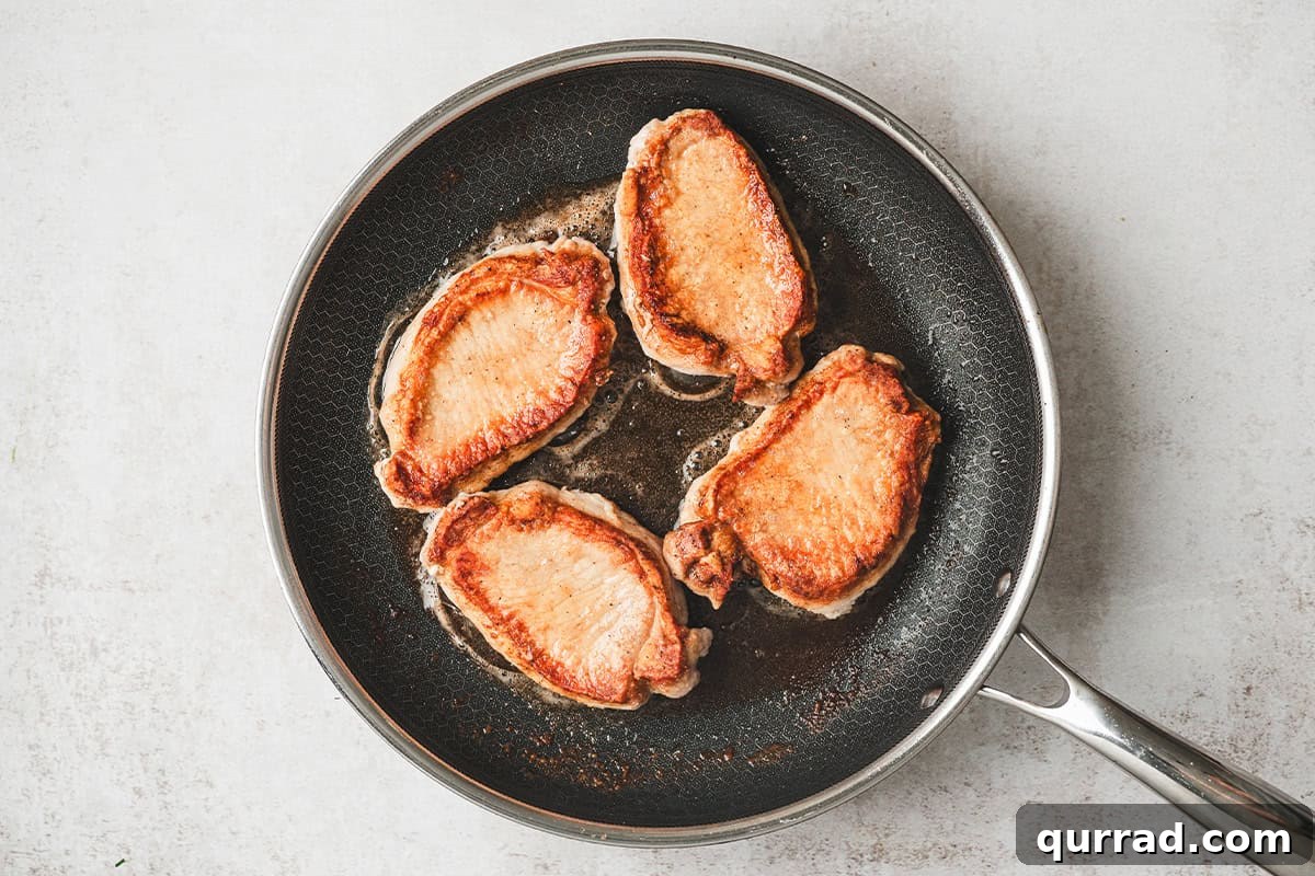 Boneless pork loin chops in a skillet.