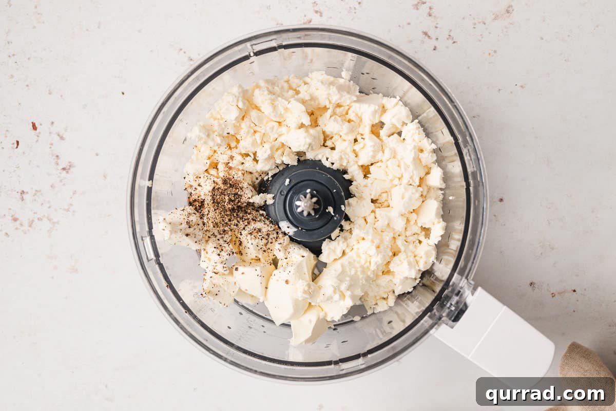 feta, cream cheese, and pepper in bowl of food processor
