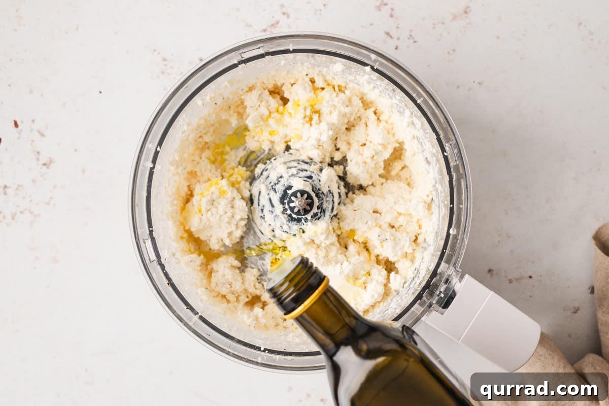 olive oil being drizzled into blended feta