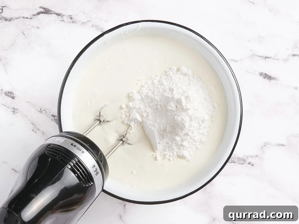 How to Make a Classic French Crepe Cake (Mille Crêpes) 7 A bowl of heavy cream with powdered sugar on top, ready to be whipped with an electric hand mixer.