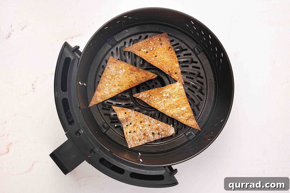 Air fryer wonton chips in an air fryer basket after cooking.