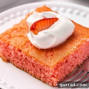 Moist Soda Cake Recipe with Creamy Vanilla Frosting 3 Side view of a slice of soda cake on a plate, topped with Cool whip and a strawberry.