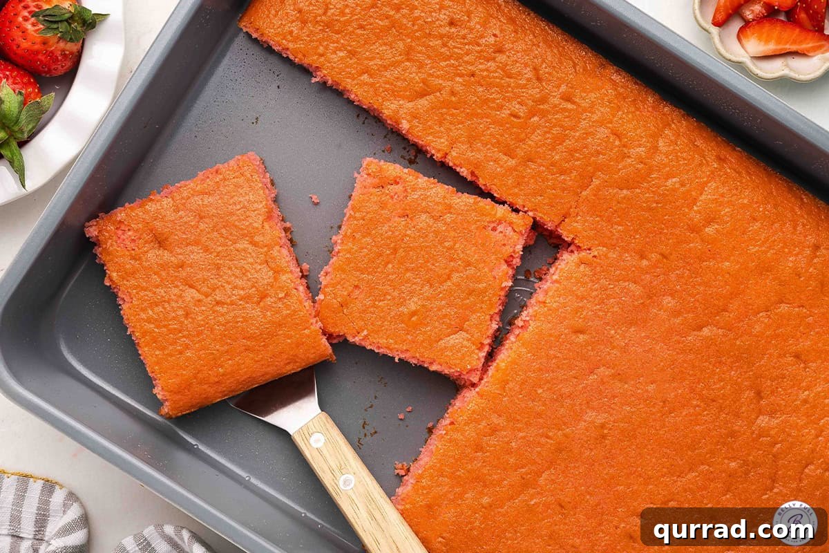 Moist Soda Cake Recipe with Creamy Vanilla Frosting 7 A soda cake in a pan with two square slices.