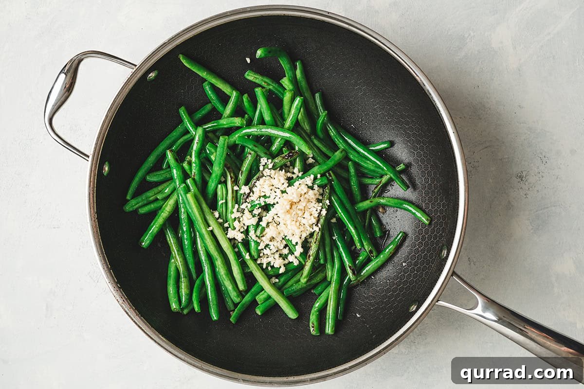 Garlic Green Beans Recipe: Sautéed with Lemon and Butter 7 Minced garlic added to a skillet with green beans.