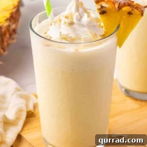 Side view of a glass of pineapple coconut orange julius.