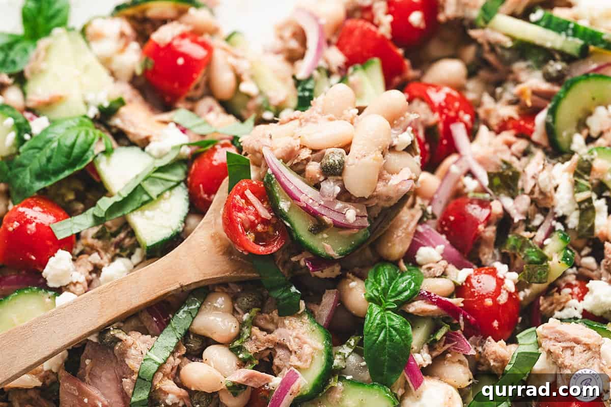 Mediterranean White Bean and Tuna Salad with Lemon Vinaigrette 8 Close up of tuna white bean salad on a wooden spoon.