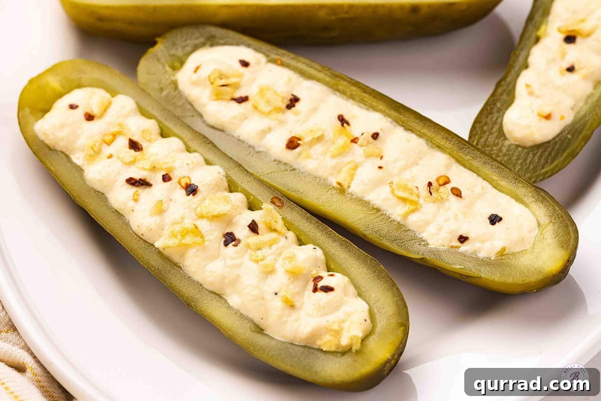 Deviled Pickles Recipe: Tangy Spicy Pickle Bites 10 Deviled pickles on a plate topped with red pepper flakes and crushed potato chips.