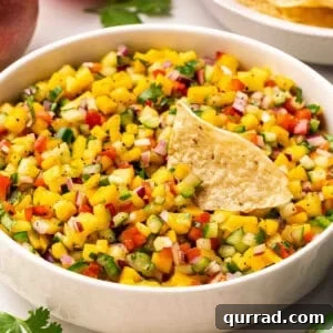 Fresh Mango Salsa Recipe with Cilantro and Lime 3 Side view of a bowl of mango salsa with a tortilla chip.