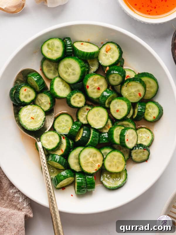 Sticky Brown Sugar-Glazed Salmon Recipe 11 Asian Cucumber Salad in white bowl with serving spoon