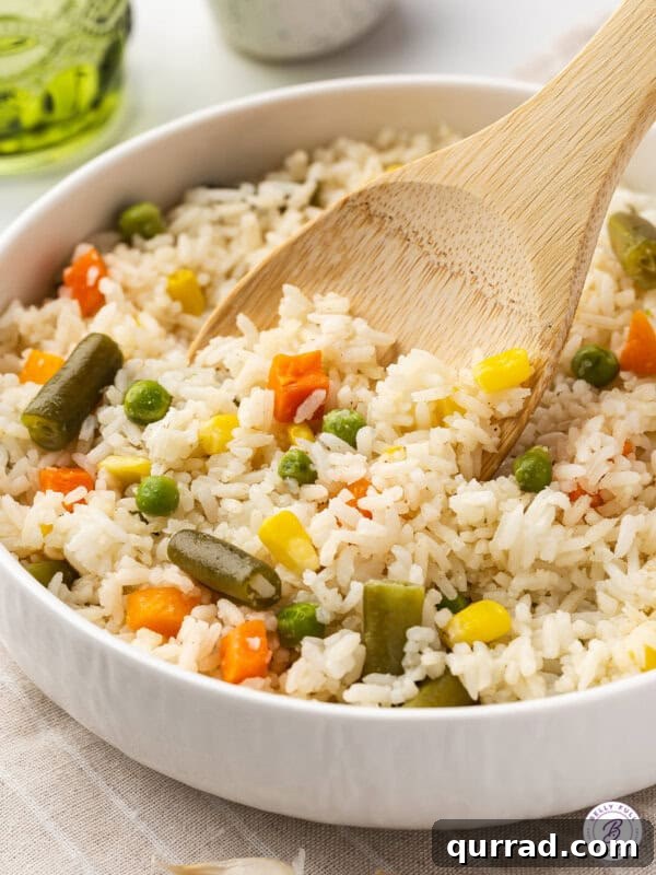 Sticky Brown Sugar-Glazed Salmon Recipe 12 A wooden spoon stirring a bowl of mixed veggies and rice