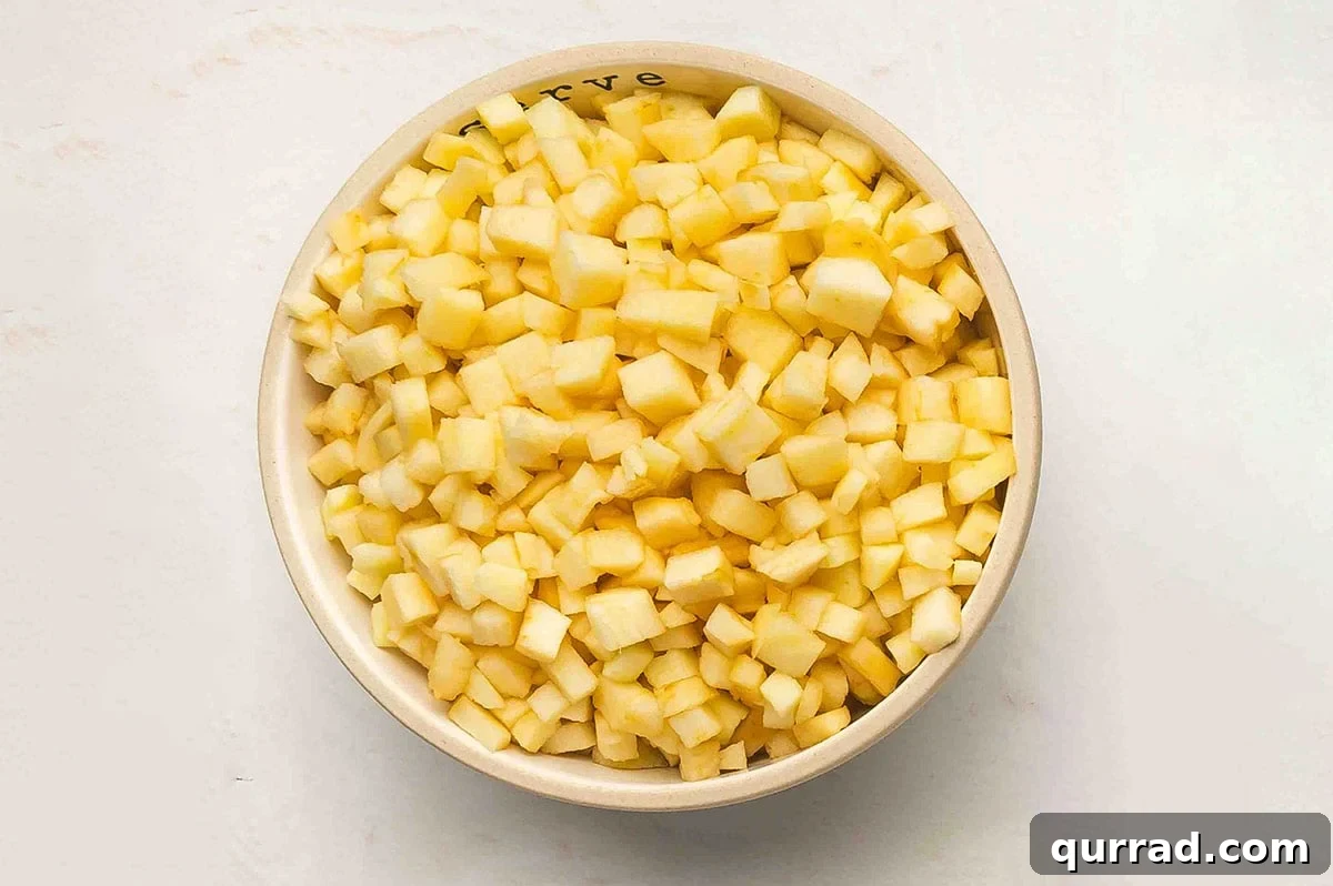 A bowl filled with peeled, cored, and finely chopped Honeycrisp apples.